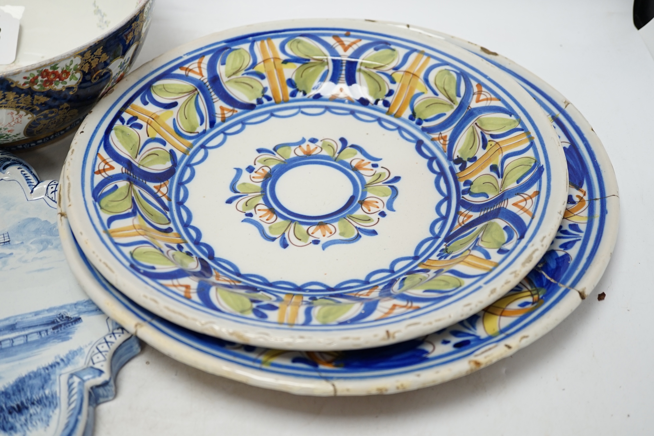A Delft blue and white plaque, two continental tin-glazed dishes, one signed V.M.D, and a Booths scale-blue bowl, largest 35cm in diameter. Condition - largest dish poor, others fair